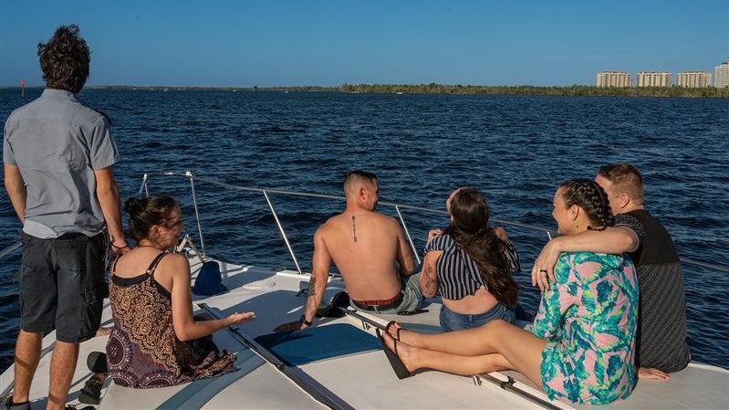 a group of people are sitting on a boat in the ocean