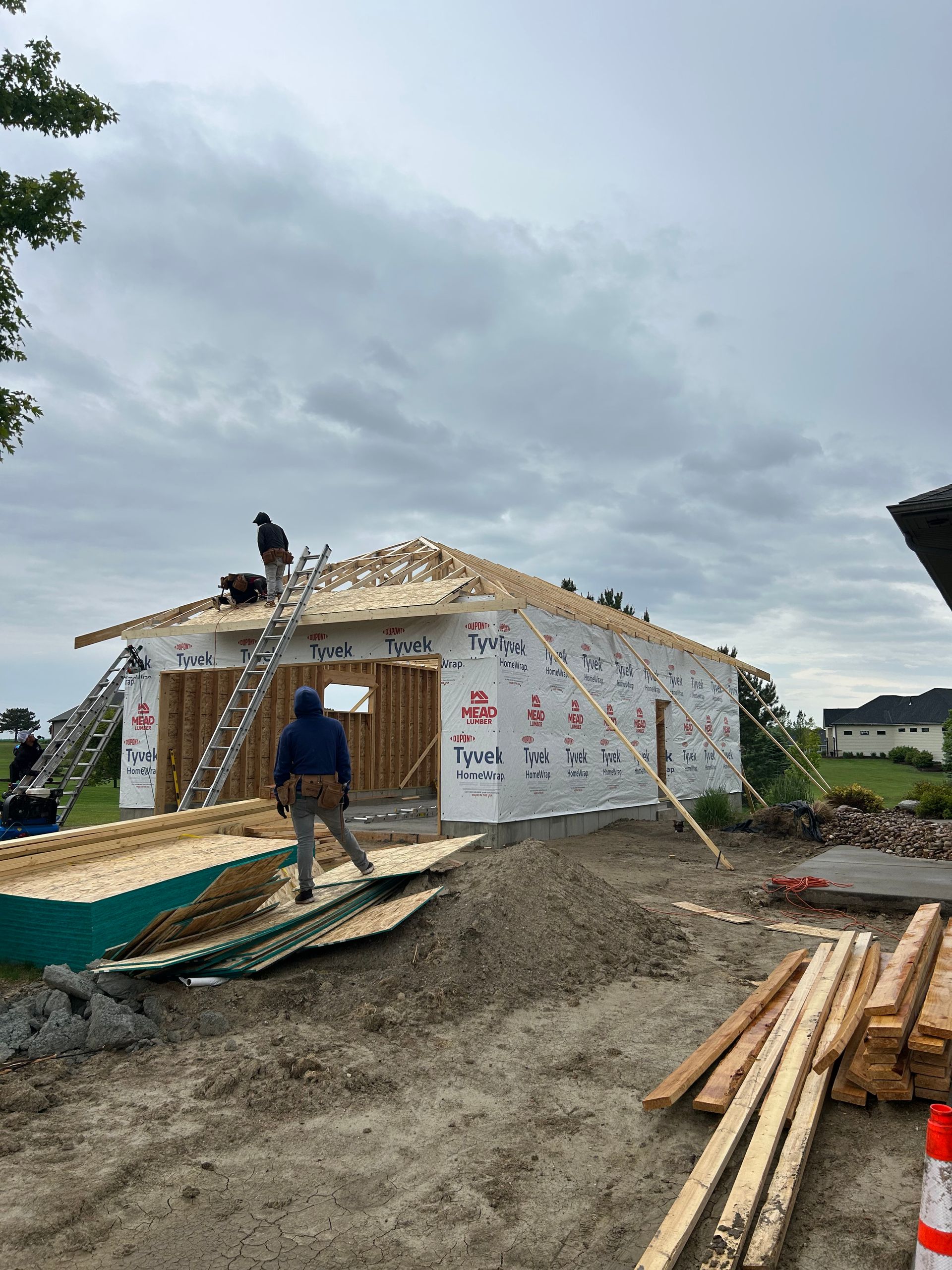 Workers roofing a small house under construction on a cloudy day