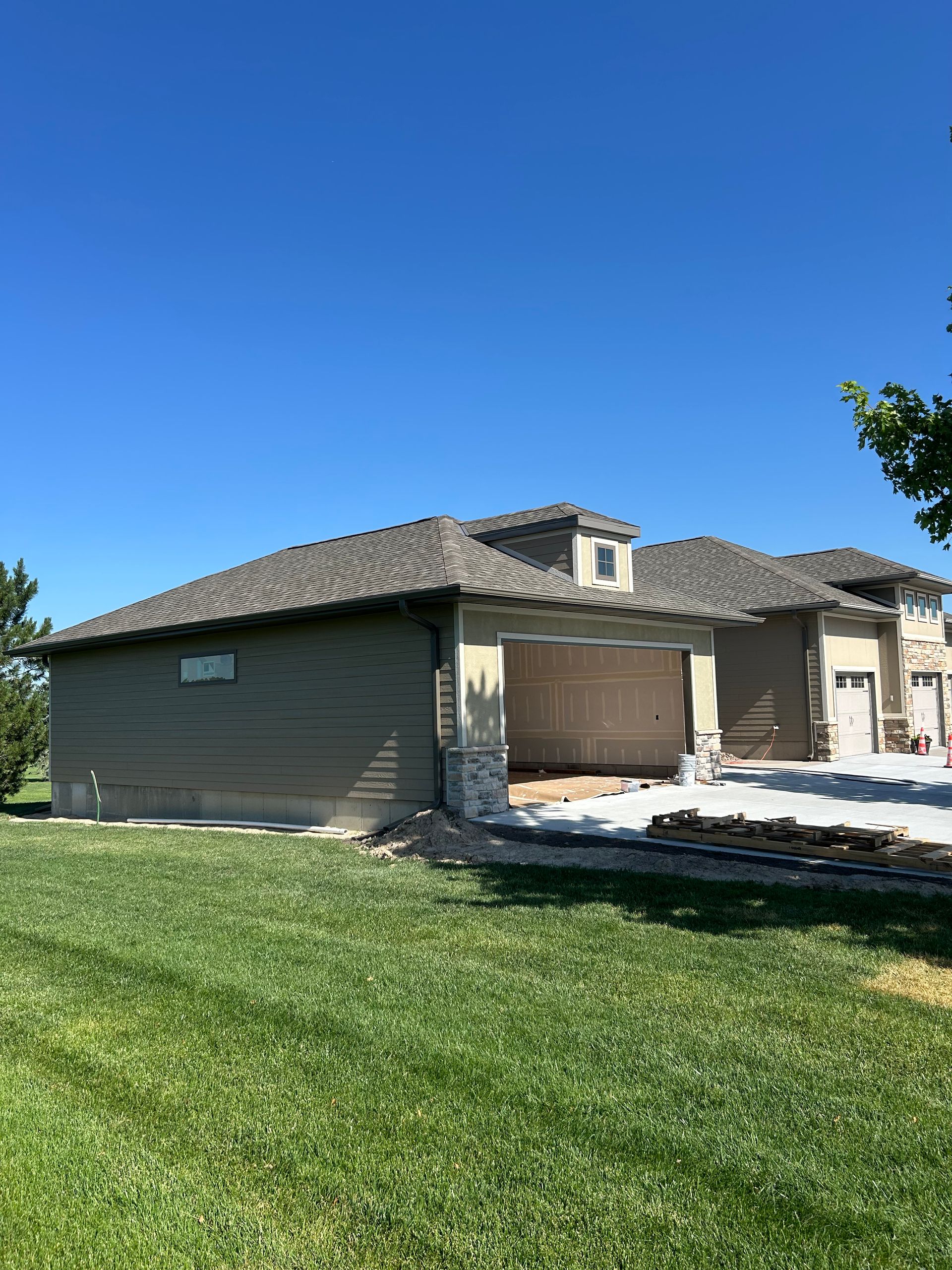Single-story stucco house with tile roof and attached garage on a sunny green lawn