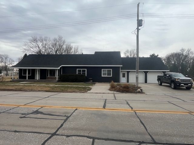Single-story house with dark roof and black truck parked in the driveway on a cloudy day