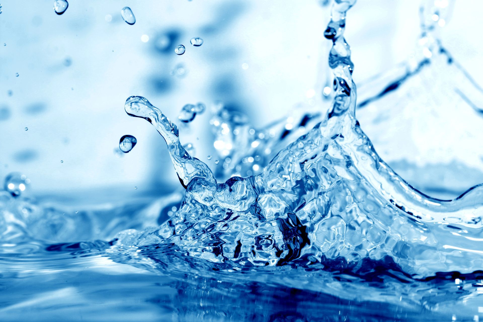 Close-up of a blue water splash with droplets suspended in the air, creating a dynamic, fluid motion.