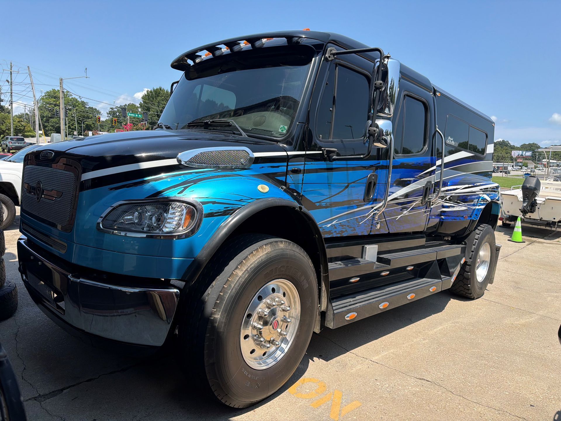 Blue semi-truck parked outdoors at a lot on a sunny day