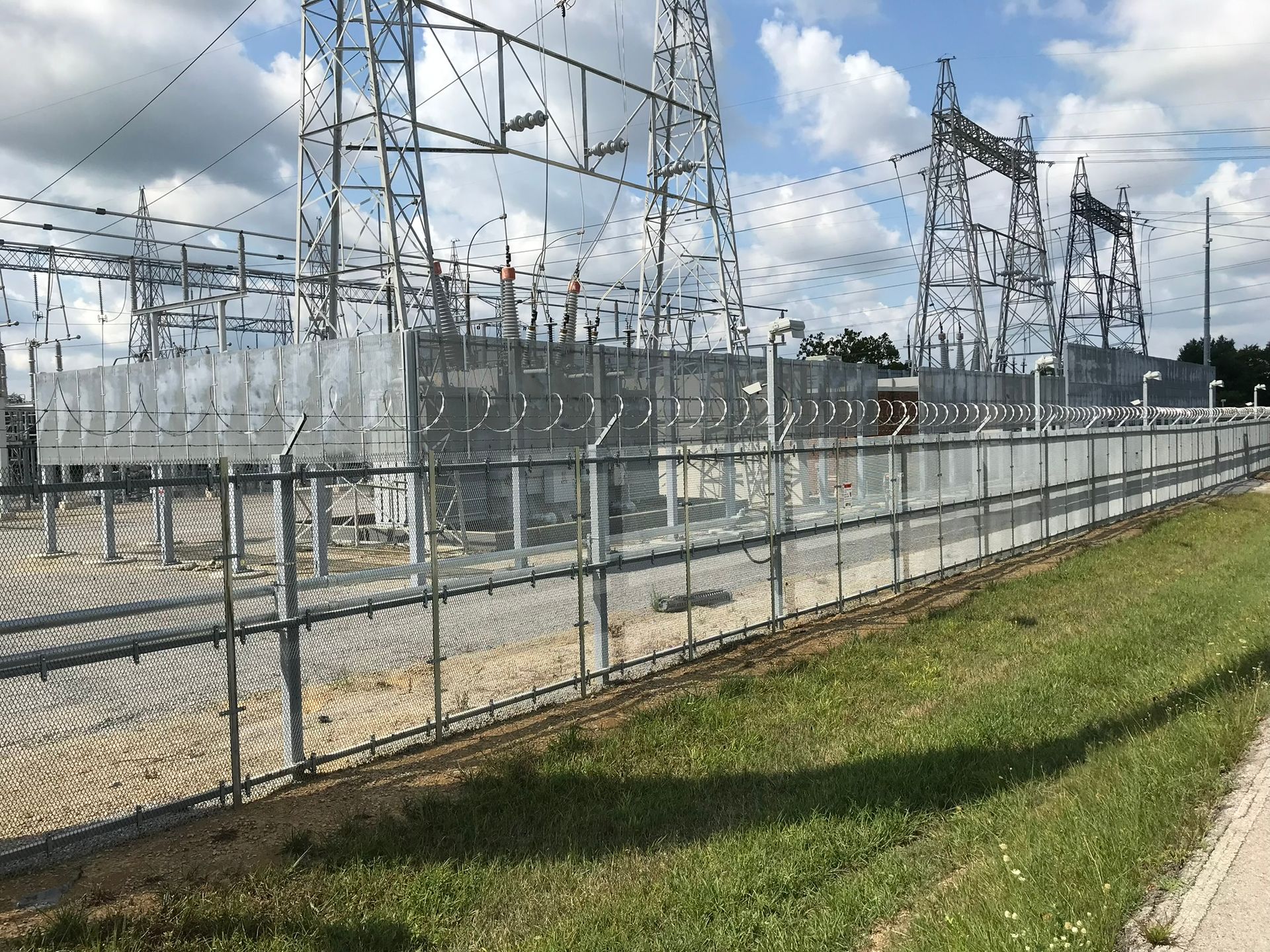 A chain link fence surrounds a power station.