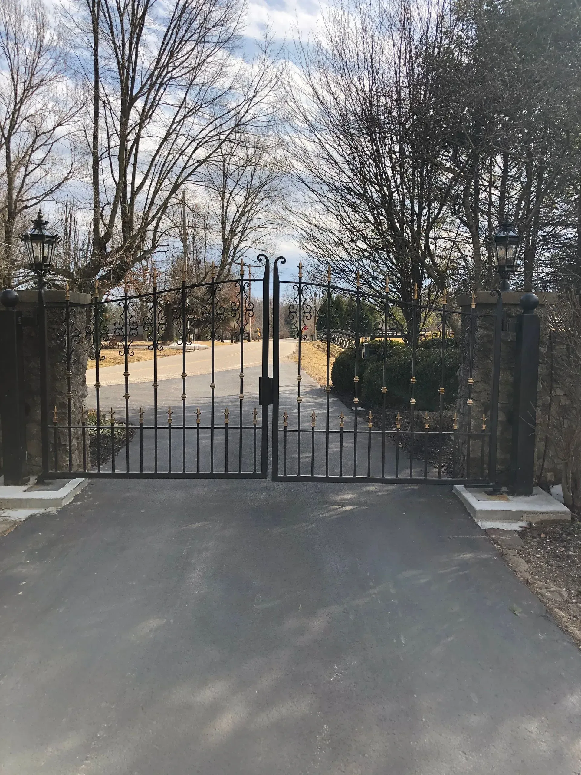 A wrought iron gate is sitting on the side of a road.