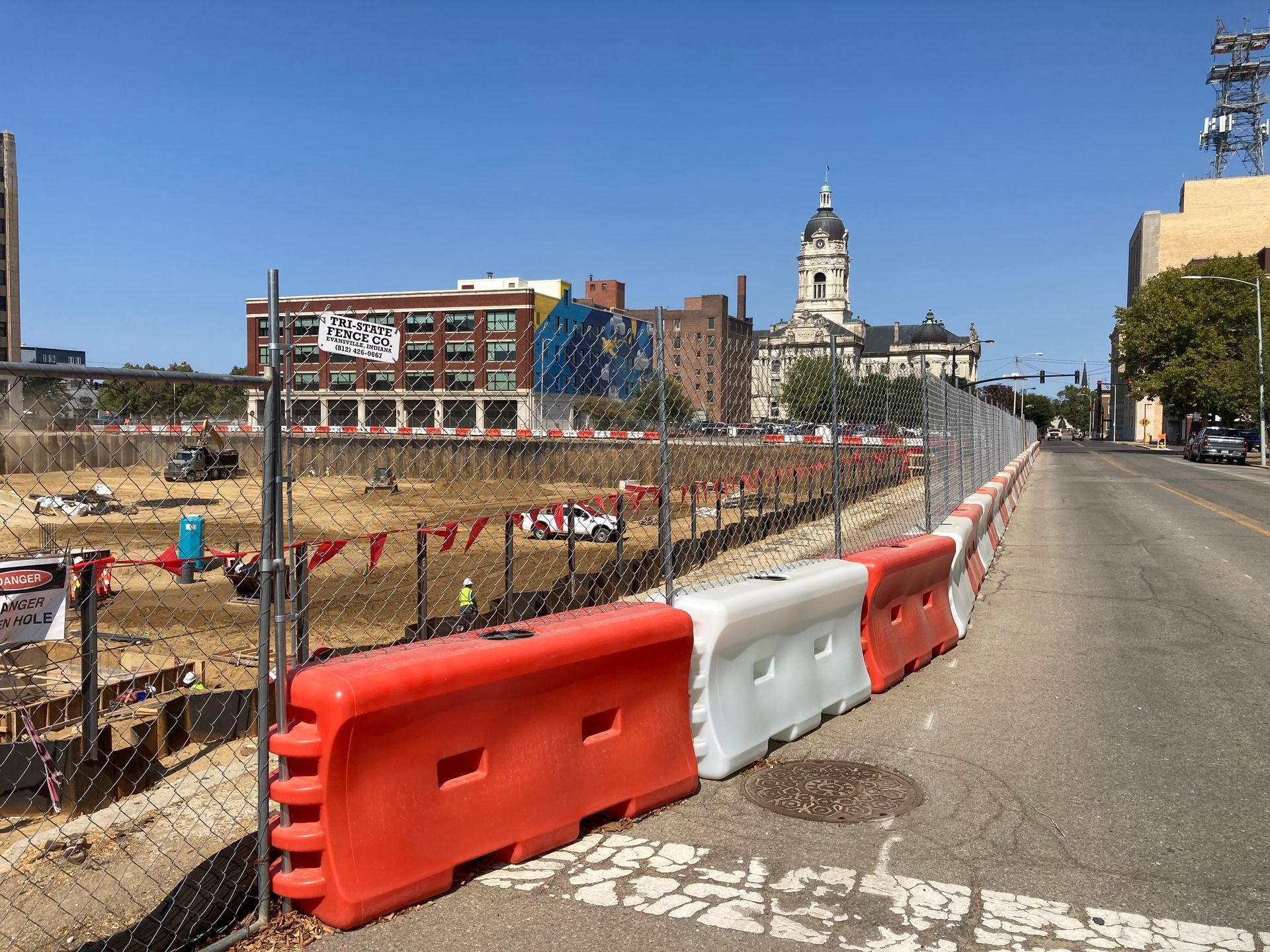 A construction site with orange and white barriers on the side of the road.