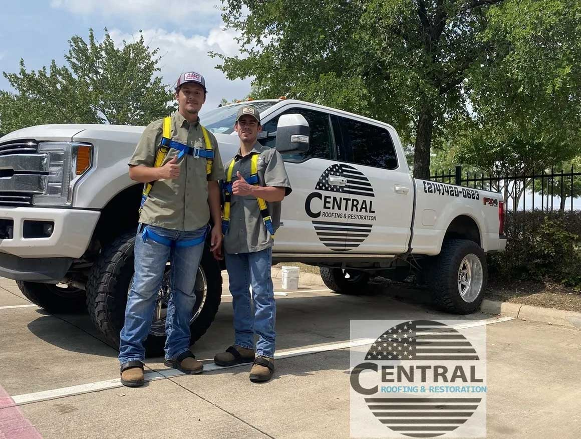 Two men are standing in front of a white truck.