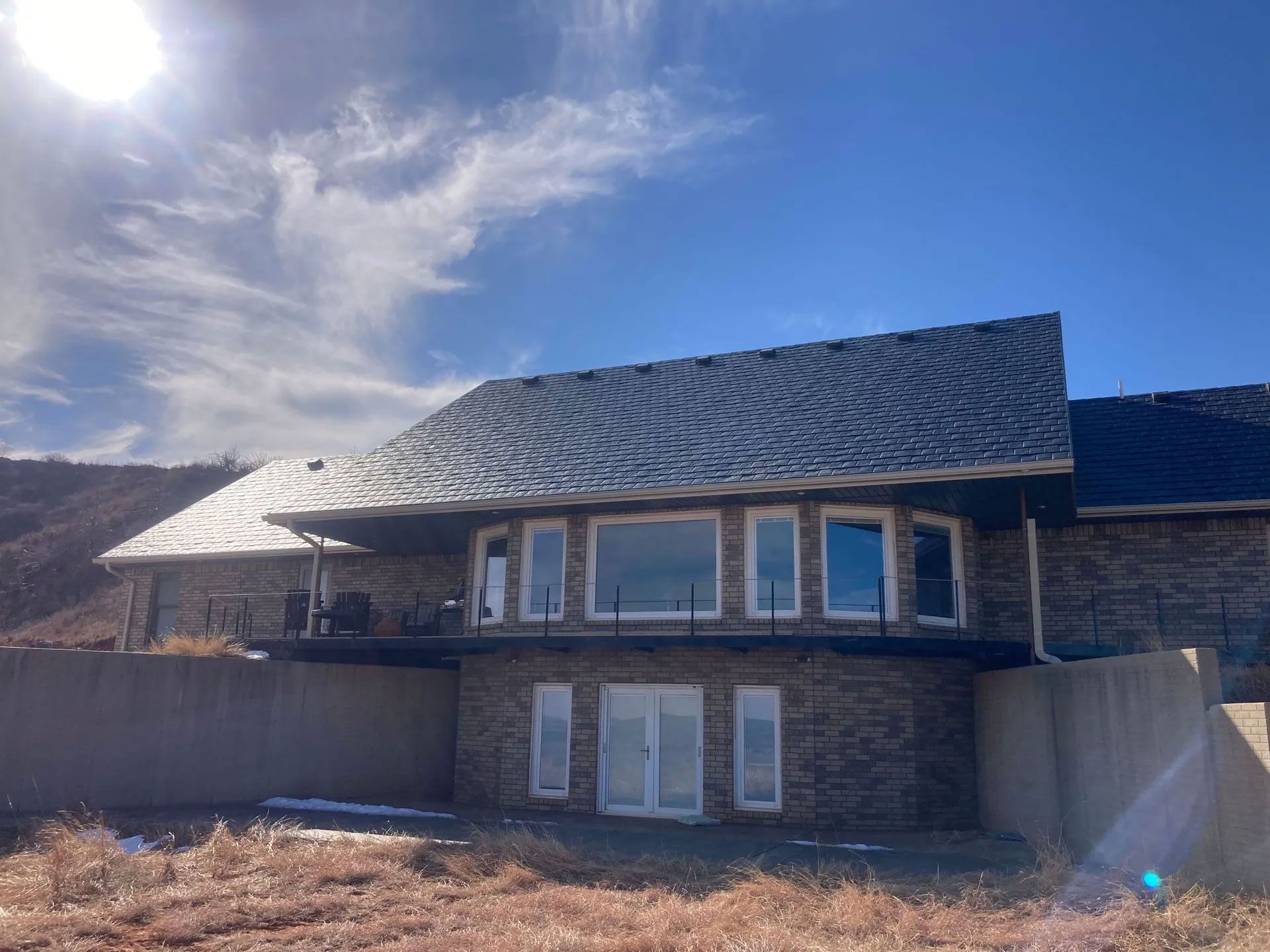 A large house with a lot of windows and a blue sky in the background.