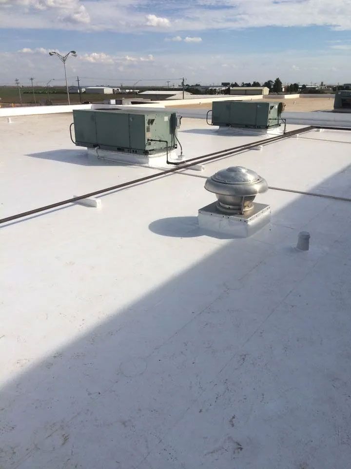 A white roof with a lot of air conditioners on it