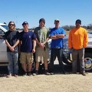 A group of men are posing for a picture in front of a truck.