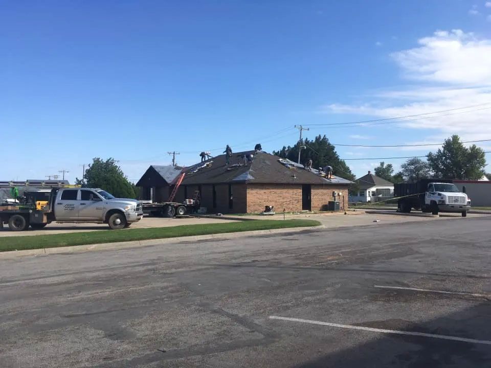 A group of trucks are parked in a parking lot in front of a building.