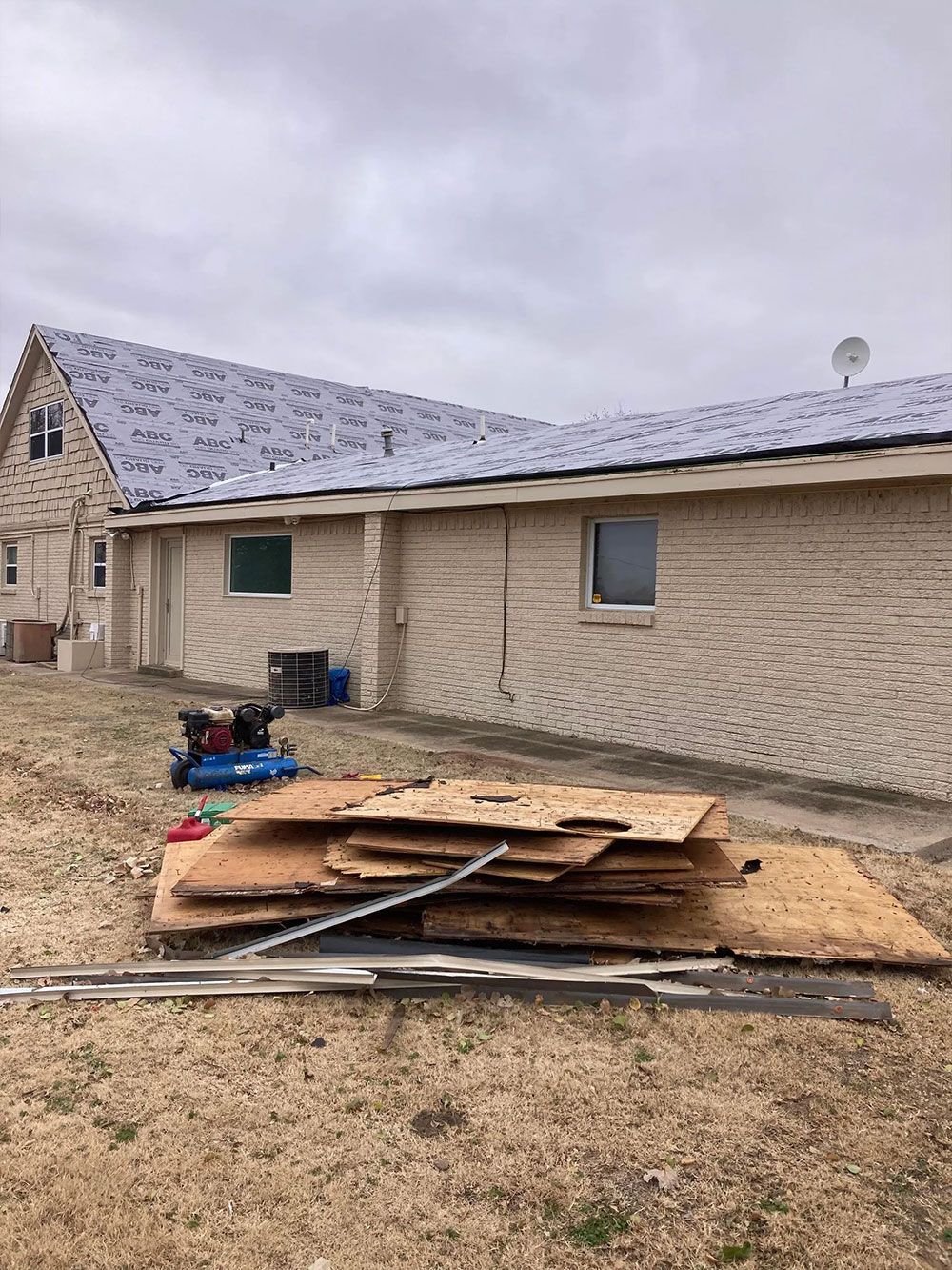 A stack of plywood is sitting in front of a house.