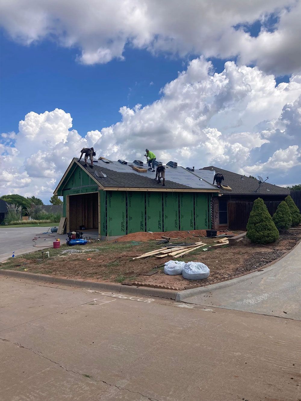 A group of people are working on the roof of a house.