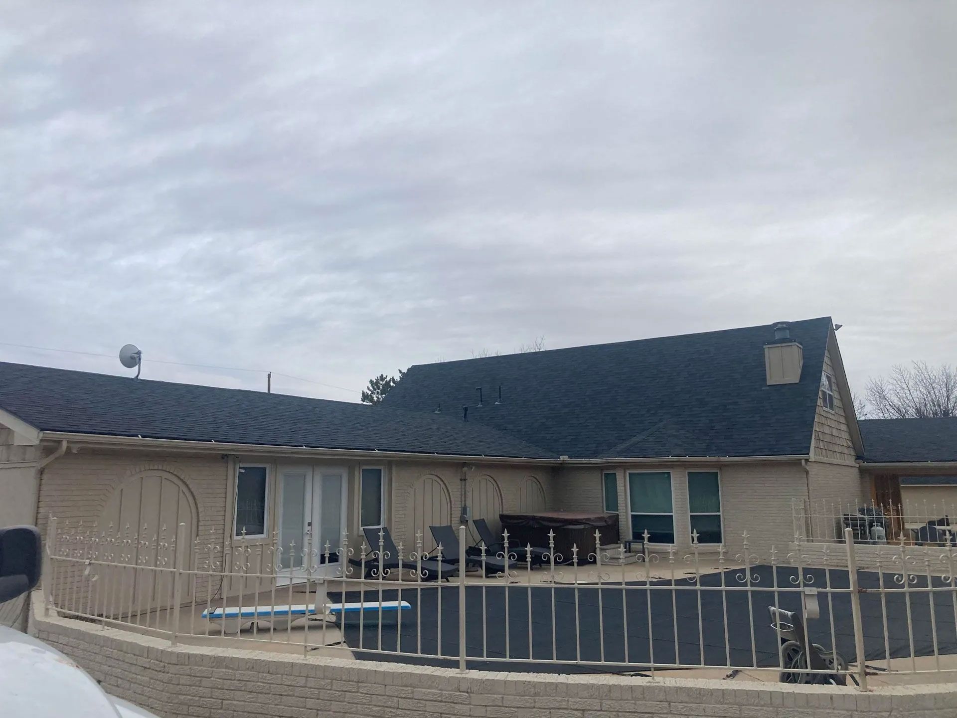 A house with a blue roof and a fence around it