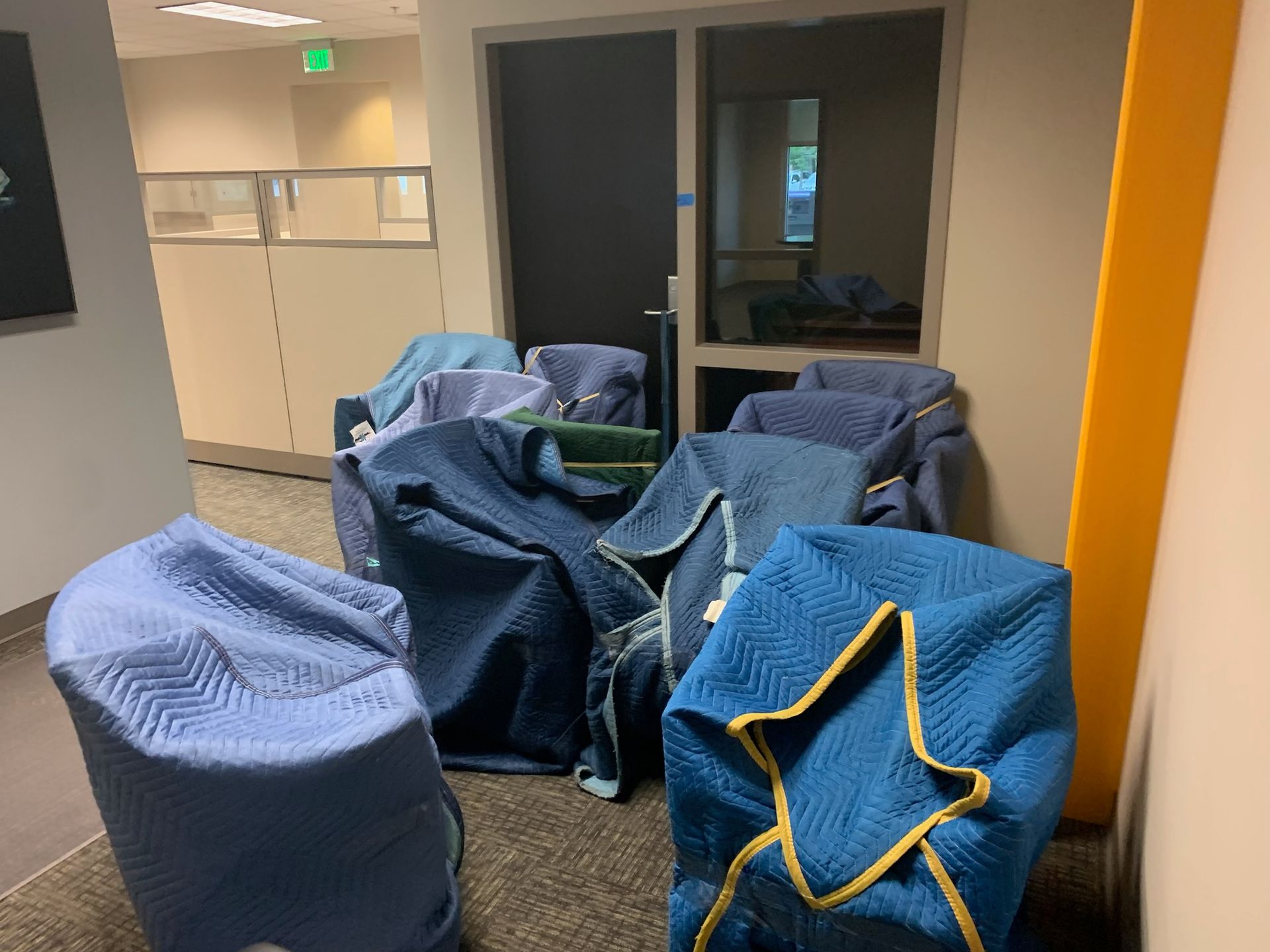 Bean bag chairs in a hallway lounge area beside office doors and a mirrored wall.