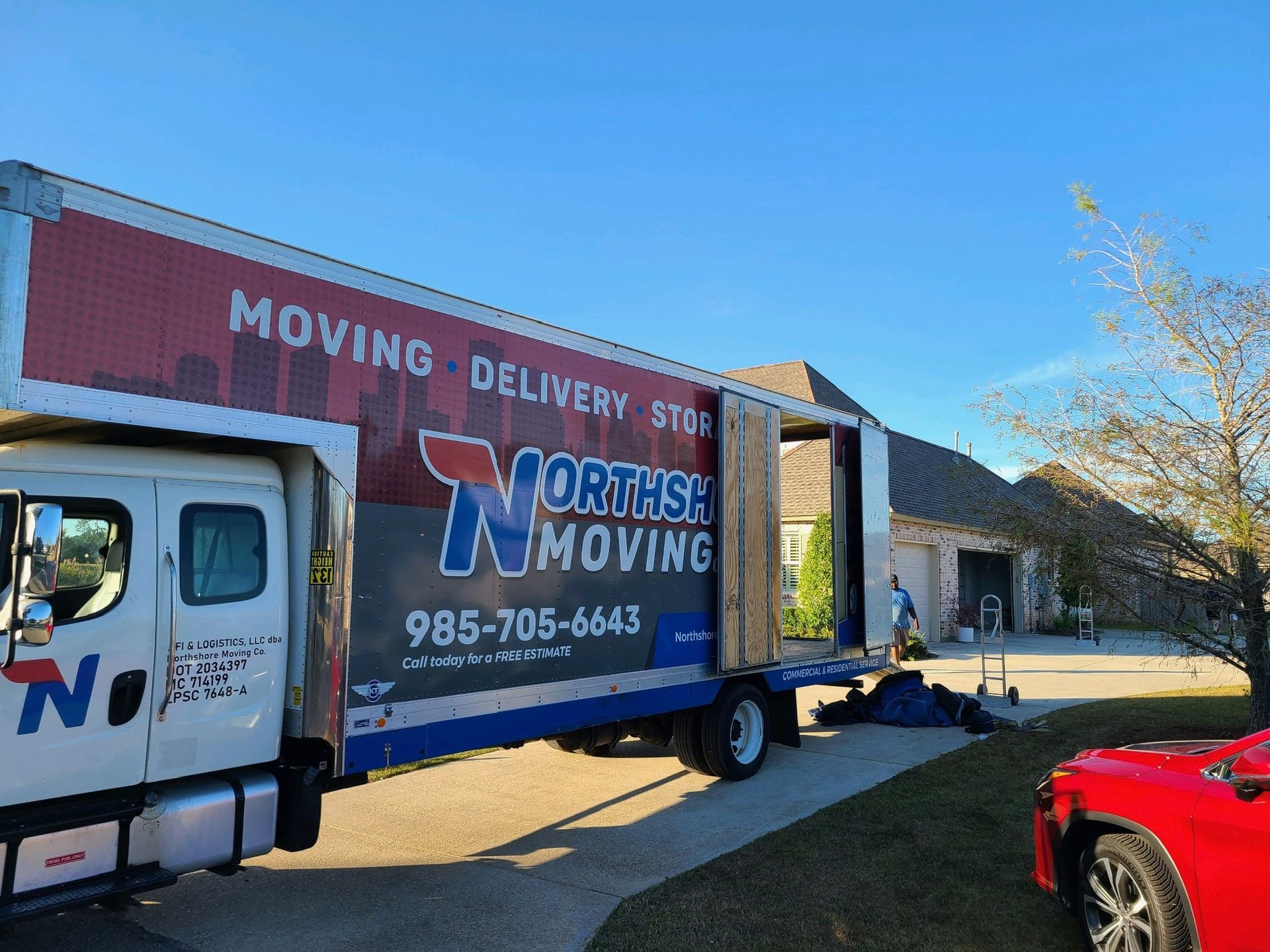 A Northshore Moving box truck parked on a residential driveway on a sunny day.
