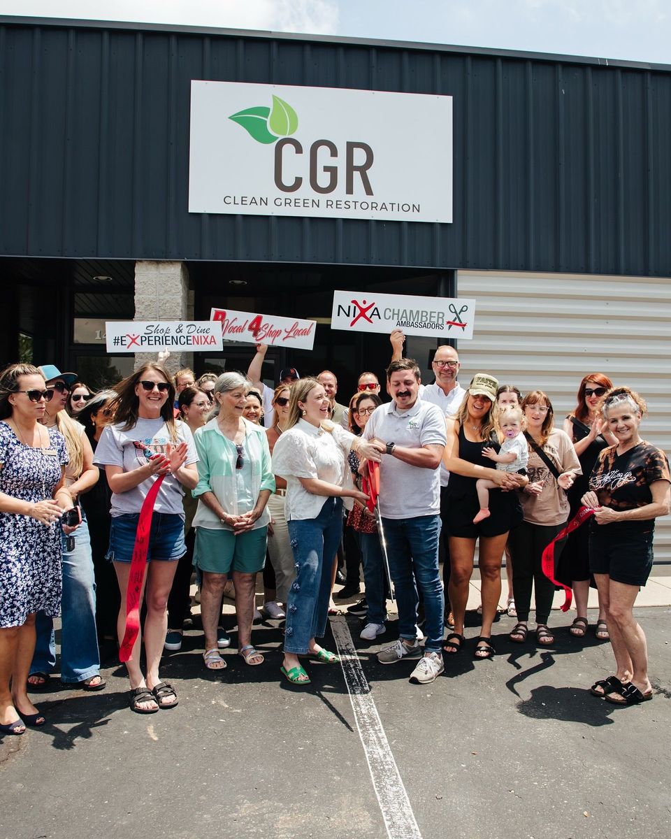 A group of people are standing in front of a building that says CGR