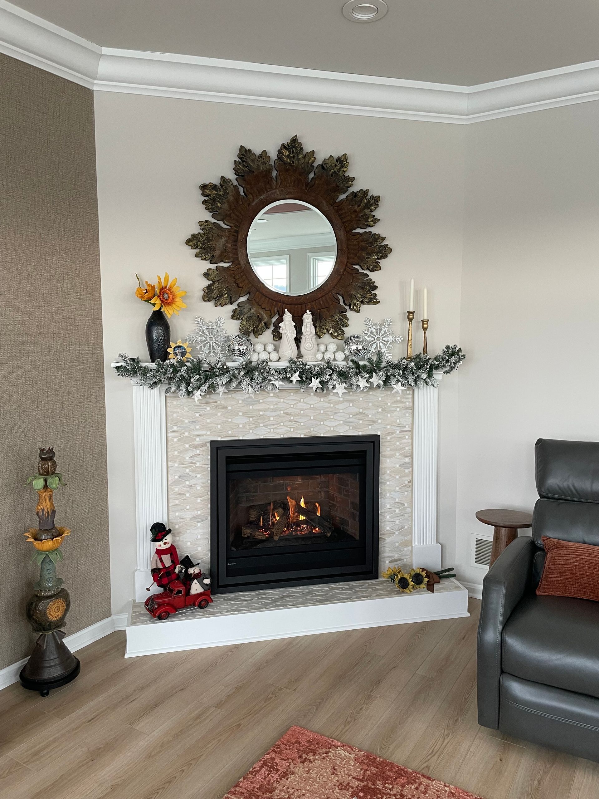 Cozy living room with decorated fireplace, mirror, candles, and a leather armchair