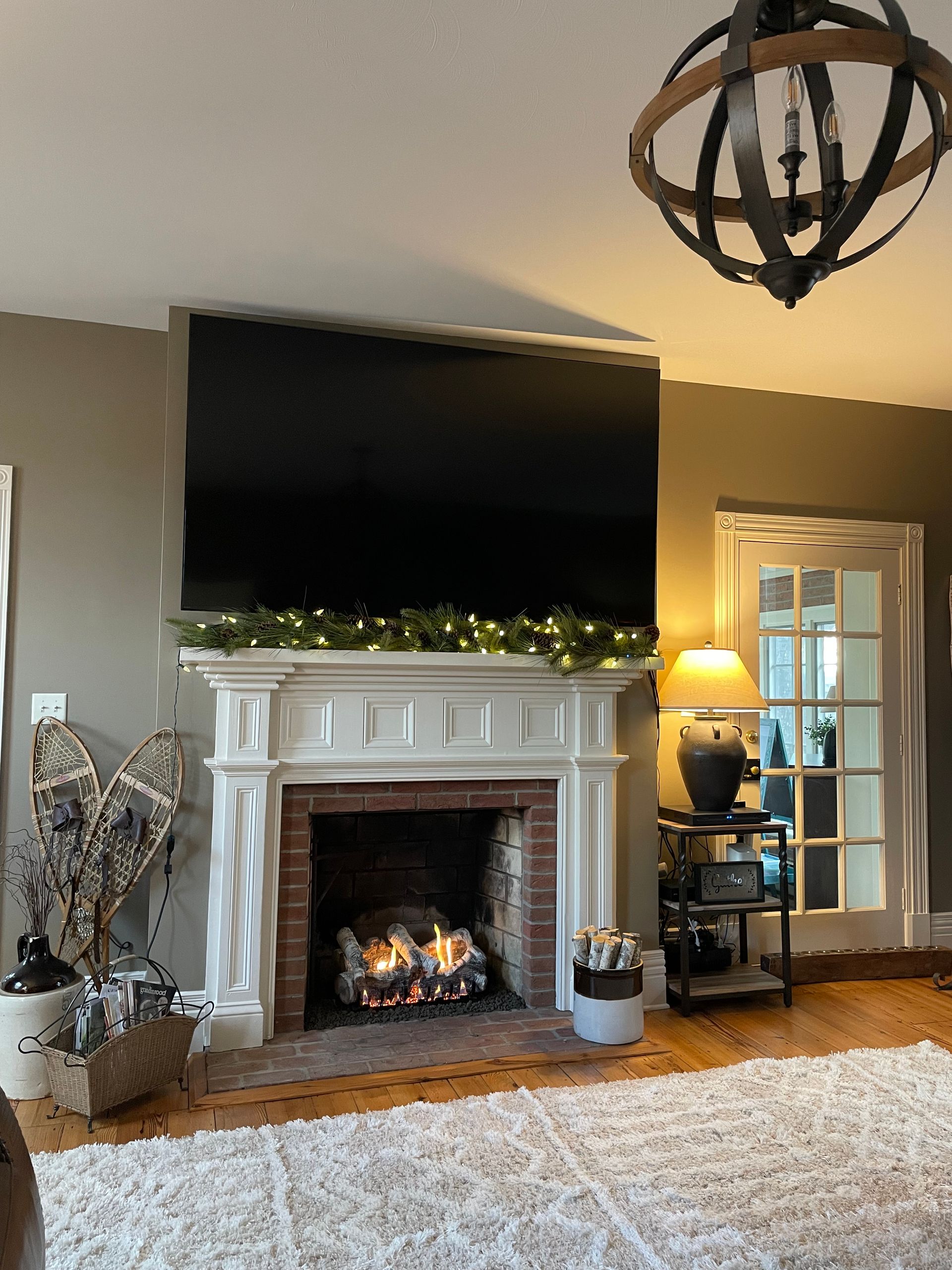 Cozy living room with a lit fireplace, large TV above the mantel, and warm decor accents