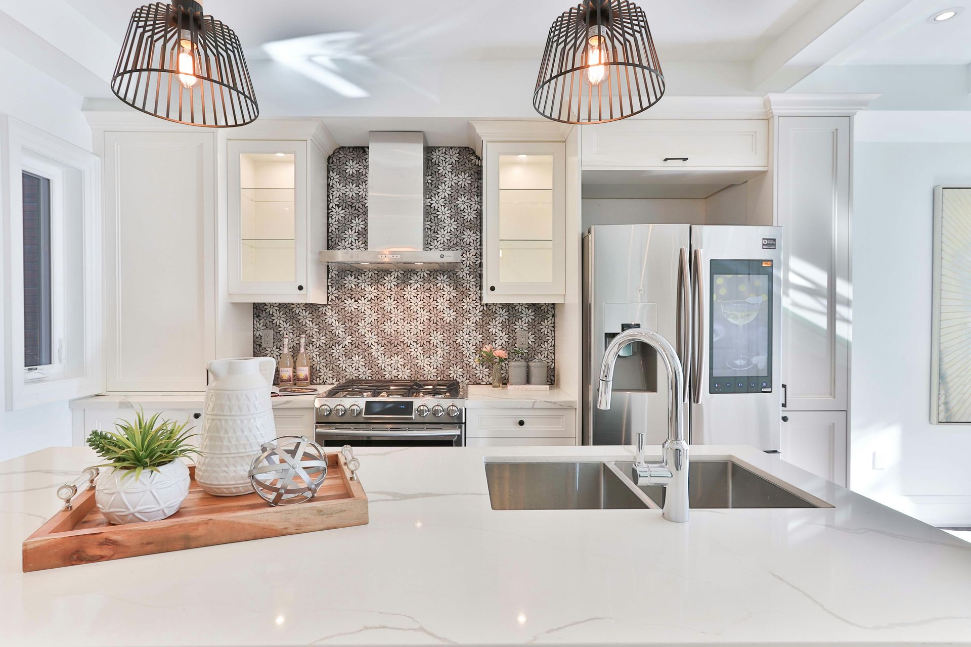 a kitchen with white cabinets, stainless steel appliances, a sink and a refrigerator