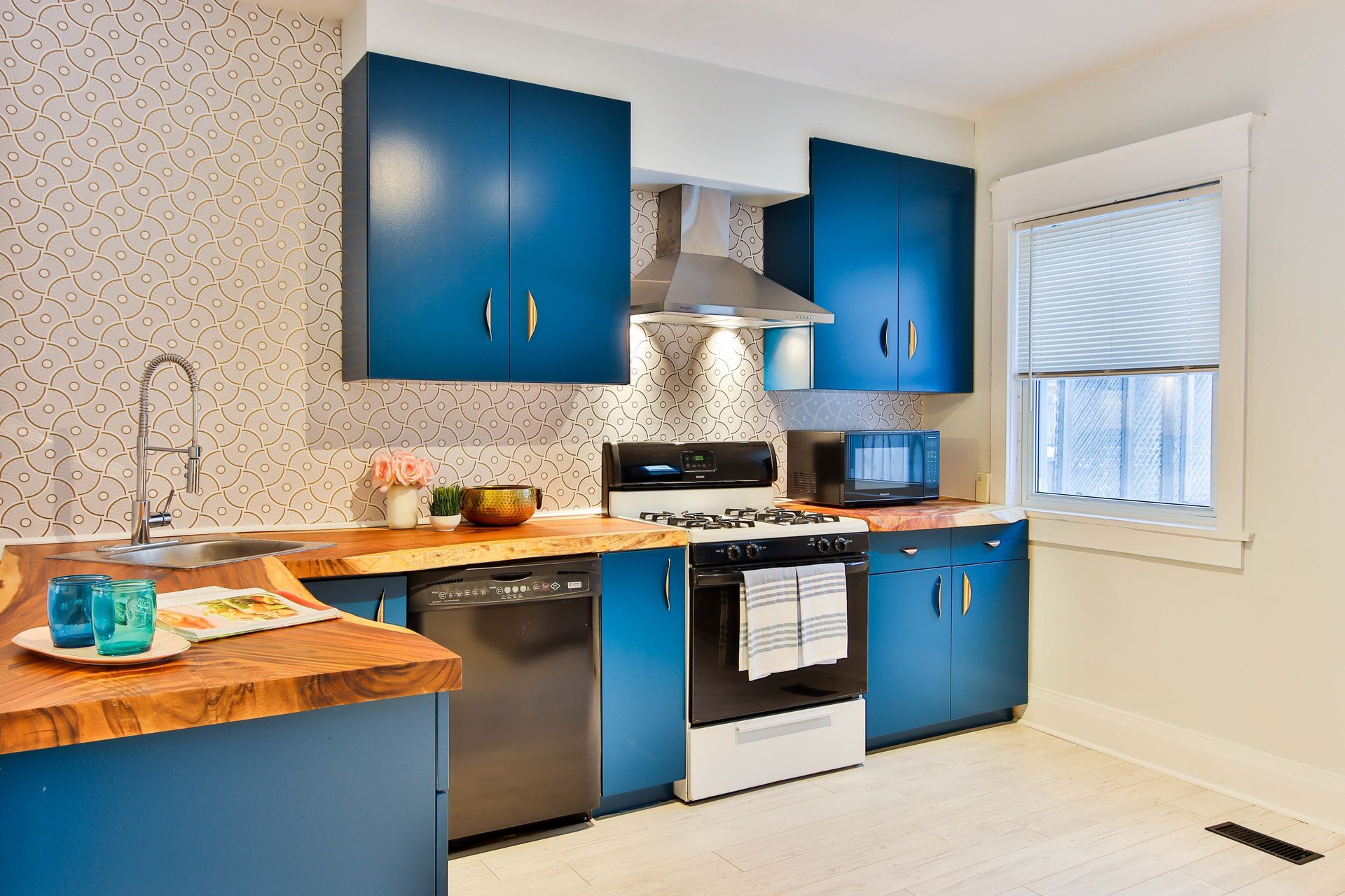 a kitchen with blue cabinets and stainless steel appliances