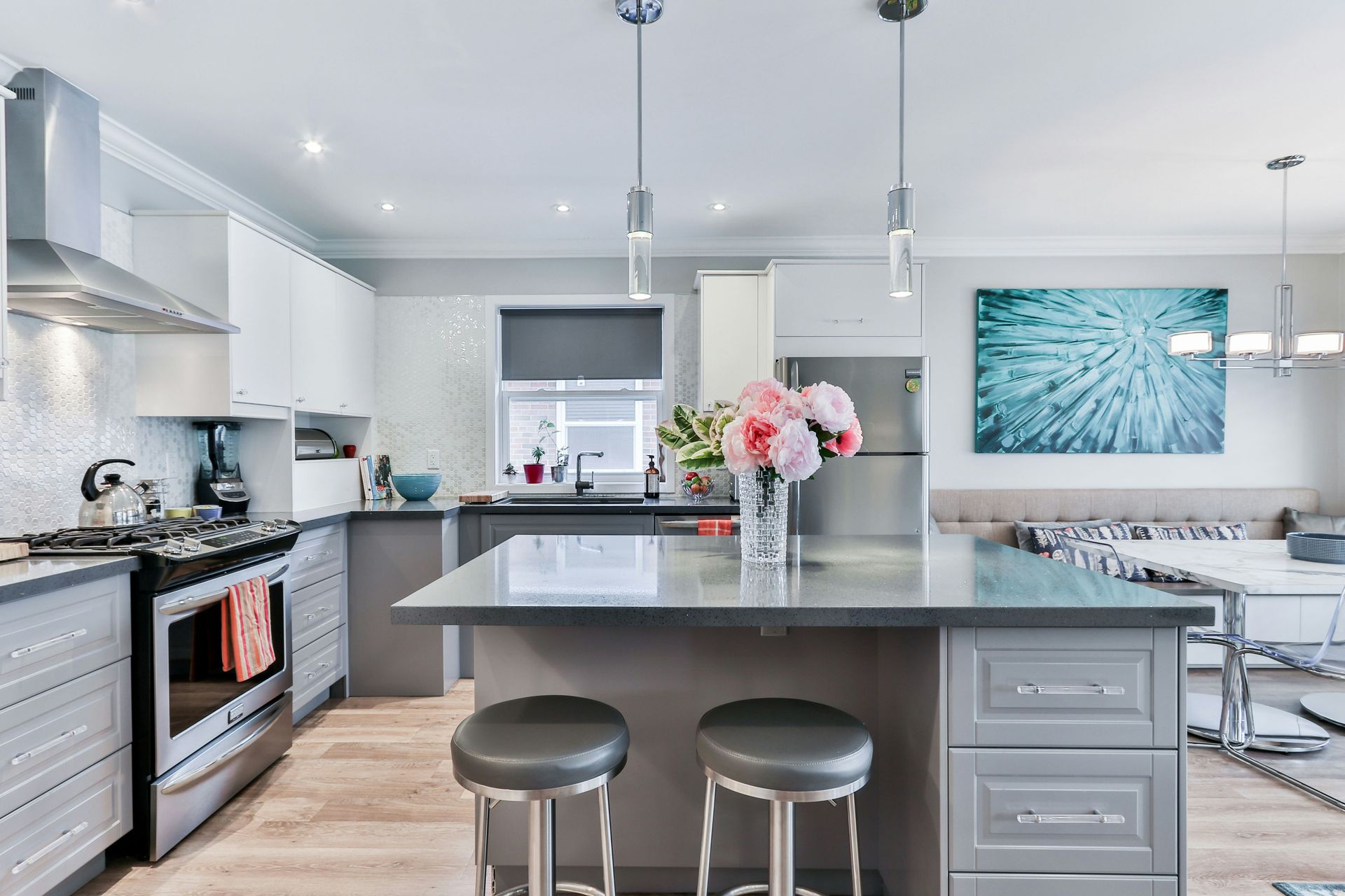 a kitchen with a large island and stools and a vase of flowers on the counter