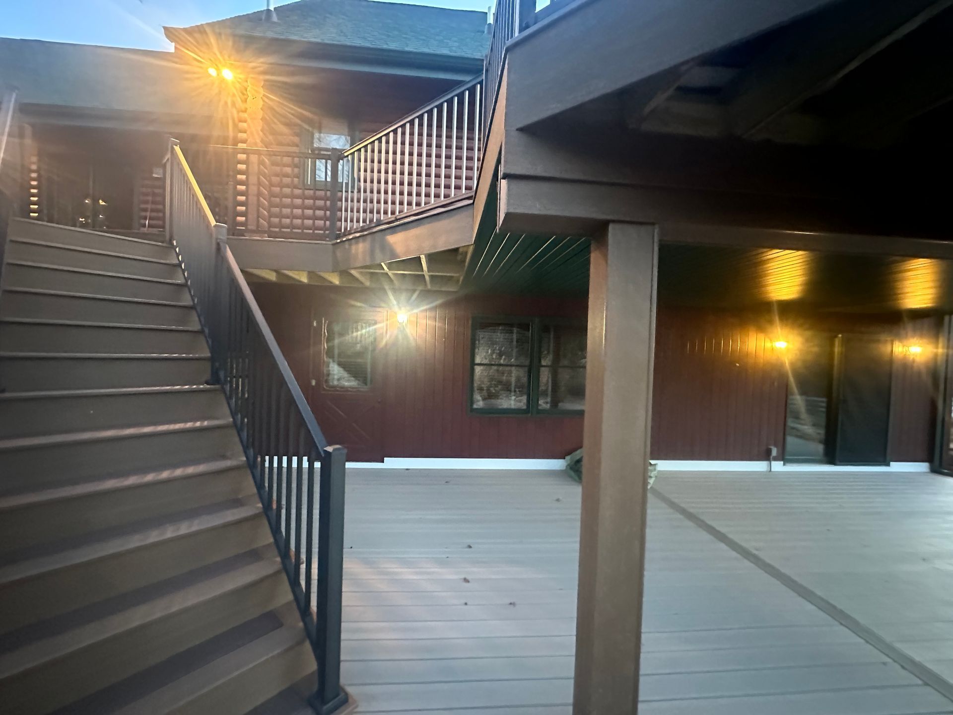 Exterior stairway and lit balcony in a courtyard at dusk