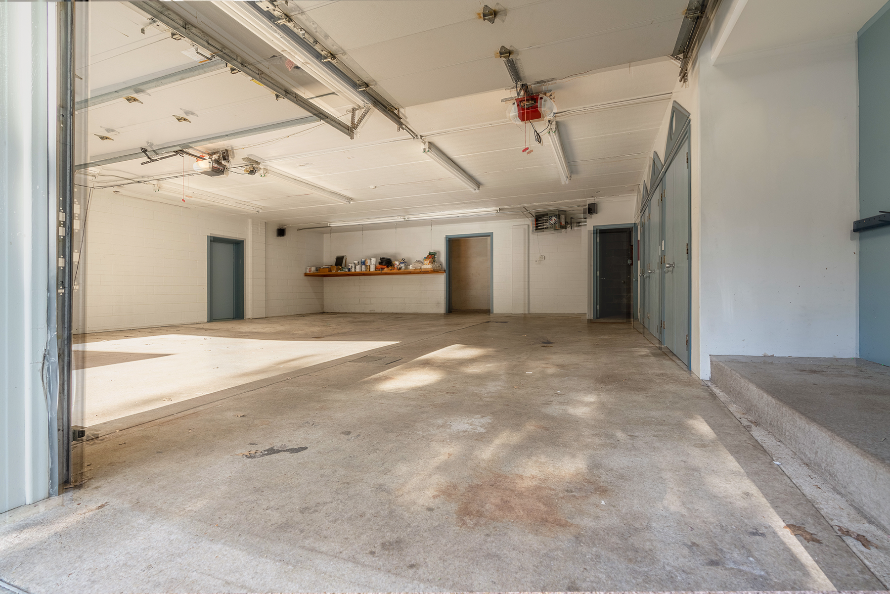 A large empty garage with a garage door open.