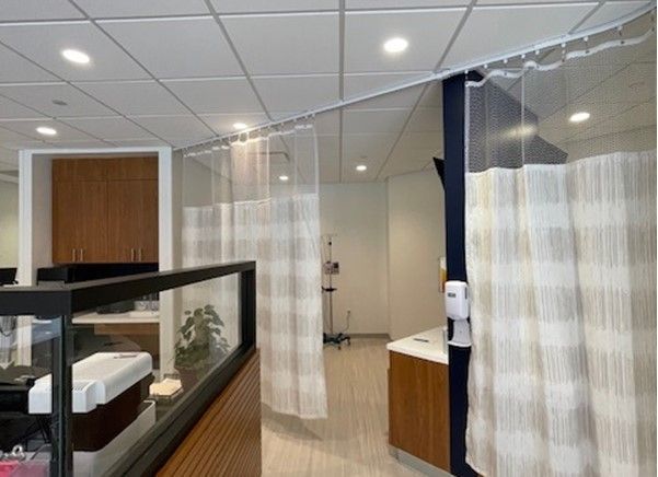 A hospital room with white curtains hanging from the ceiling