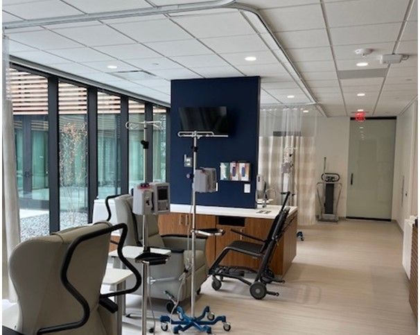 A hospital room with chairs and a tv on the wall
