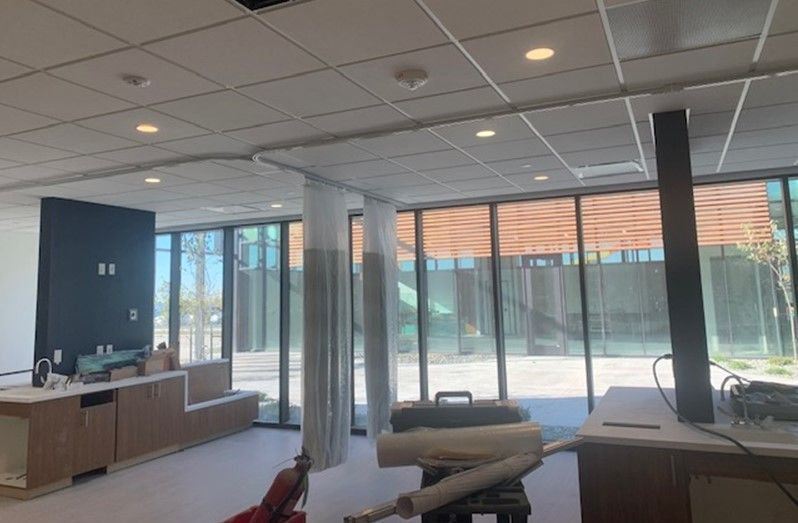 A large room with a lot of windows and a vacuum cleaner