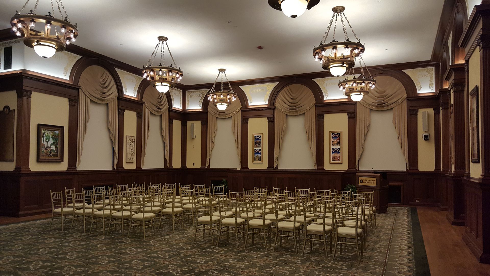 A large room with rows of chairs and chandeliers