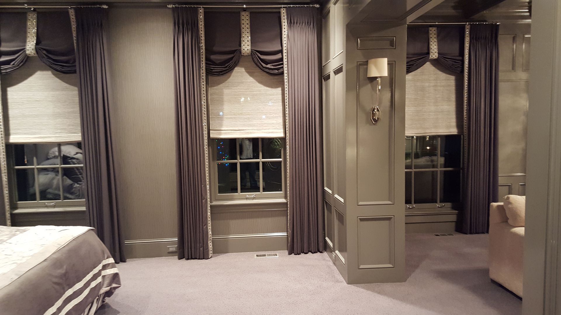 A bedroom with a bed , chair , and lots of windows.