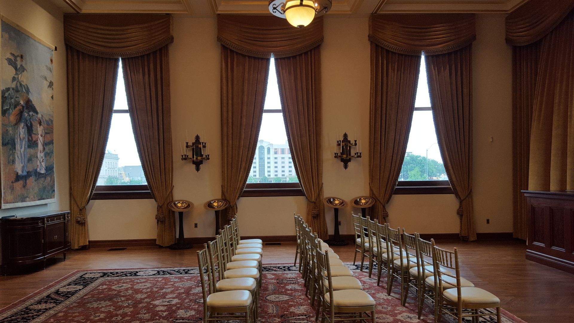A row of chairs are lined up in a room with lots of windows.