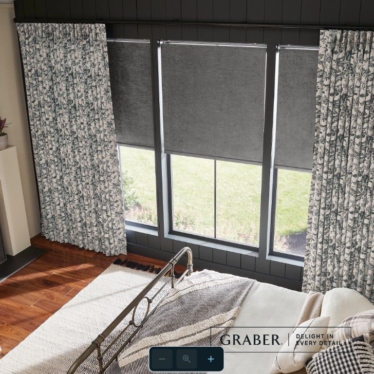 A bedroom with a bed and a window with graber written on it.