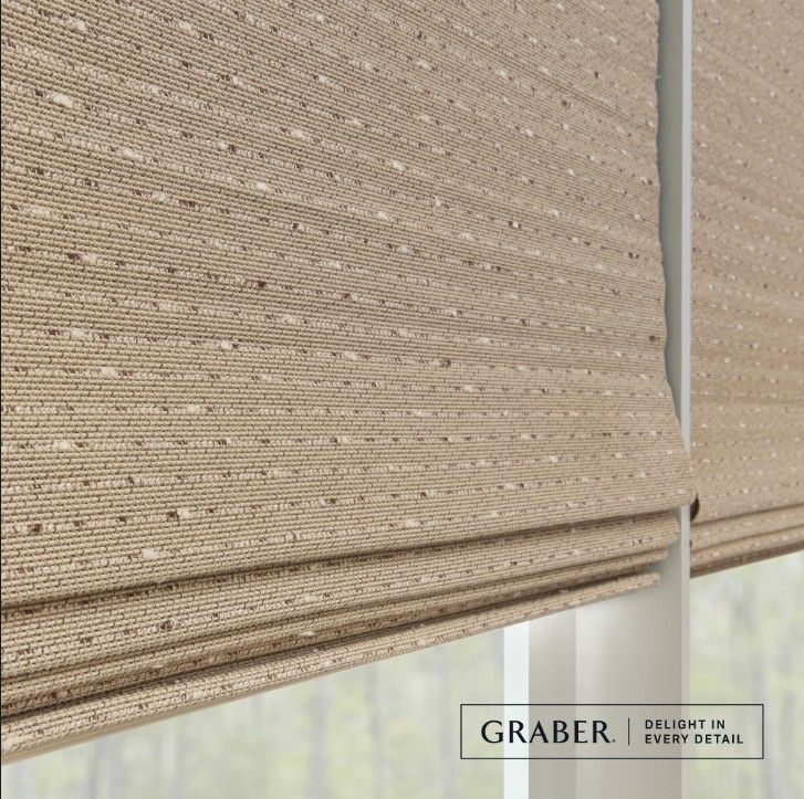 A close up of a graber roman shade on a window.