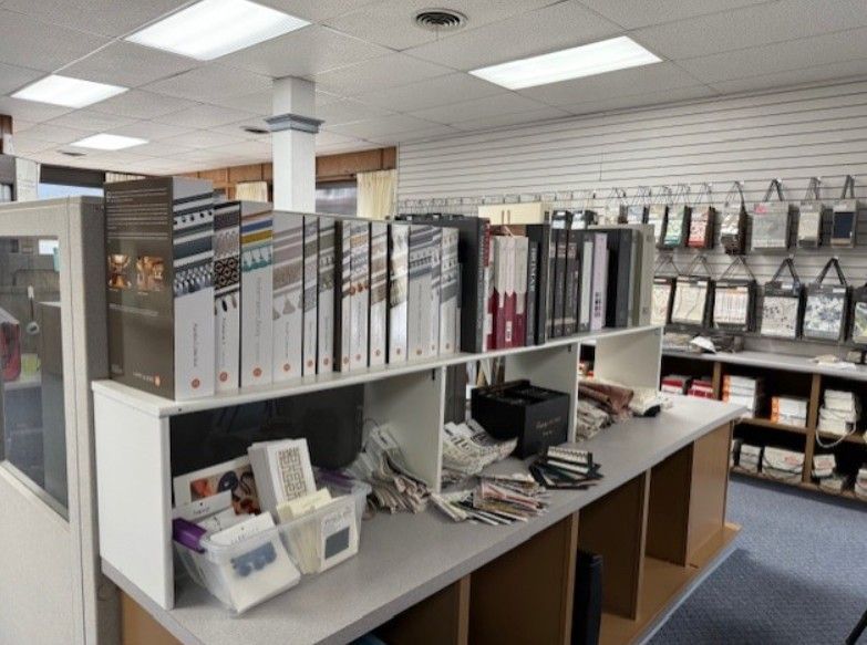 interior of a design store, showcasing fabric sample books and hanging displays on shelves