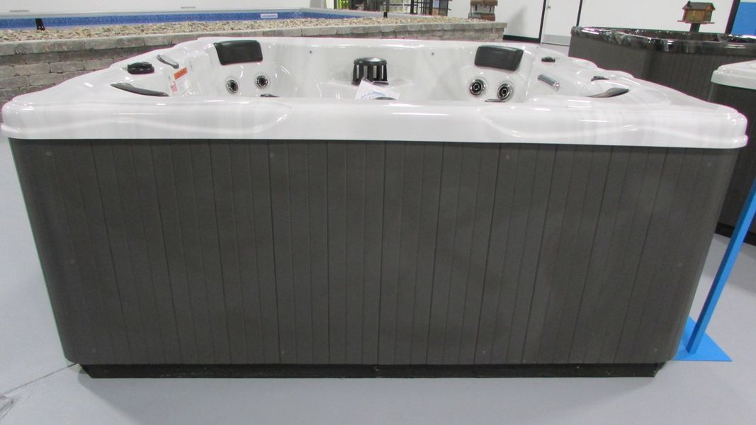 Hot tub with gray siding and white interior, in a store setting.