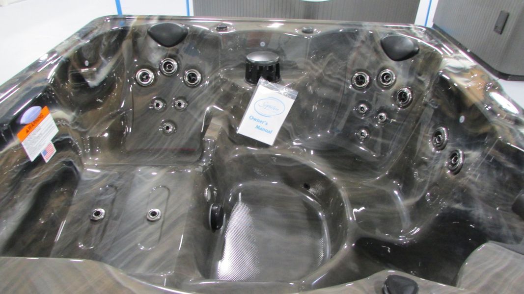Dark gray hot tub with multiple jets and seating areas.