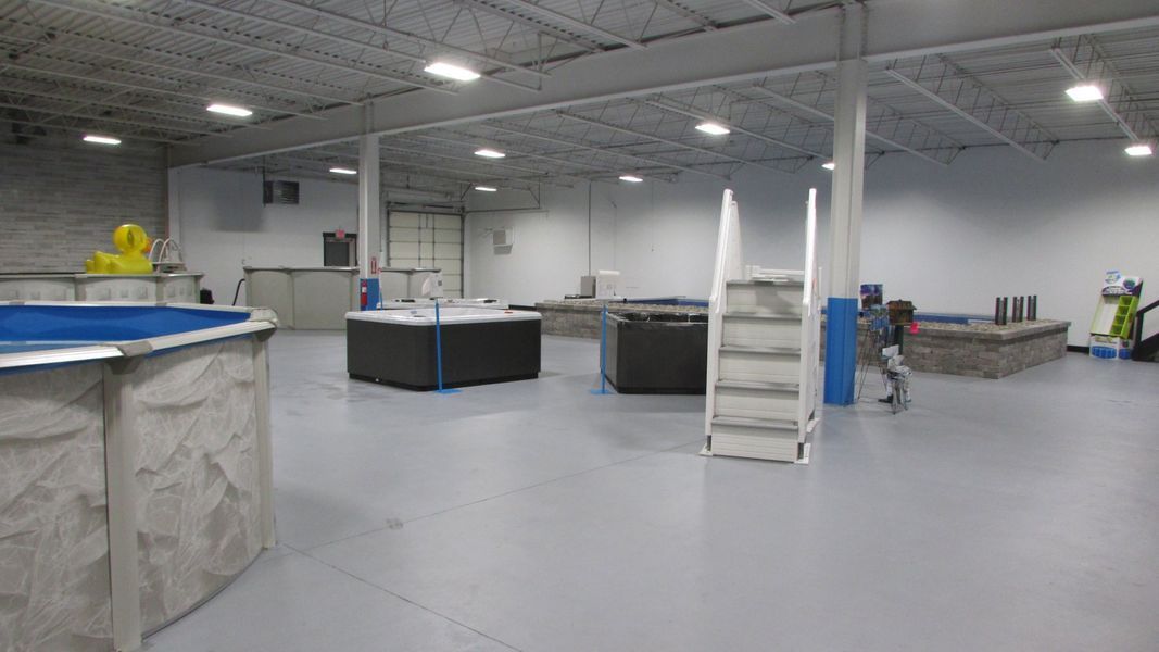 Indoor dog swimming facility with several pools and a ramp.