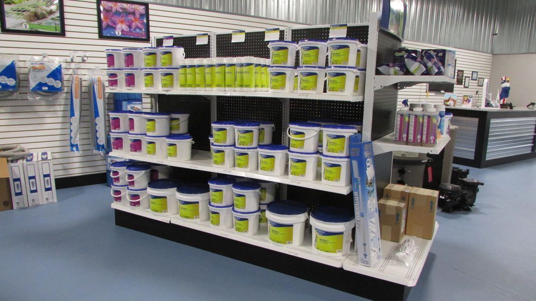 Shelves stocked with pool chemicals in a store; various sizes and colors of containers.