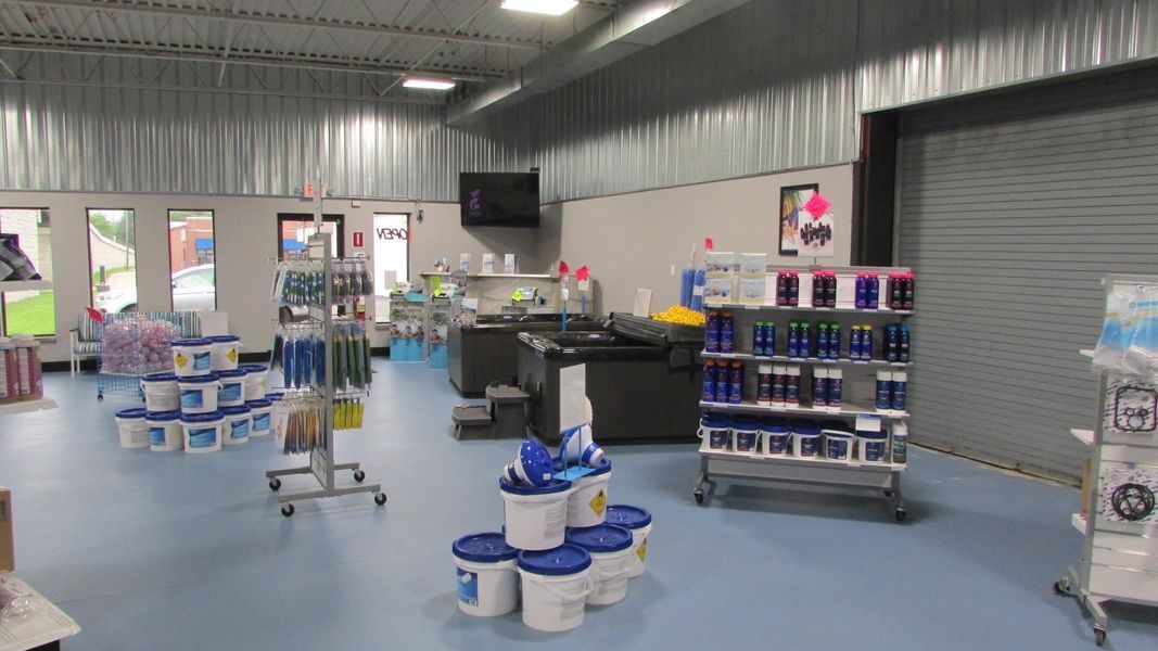Interior of a store, with shelves of swimming pool supplies, blue floor.