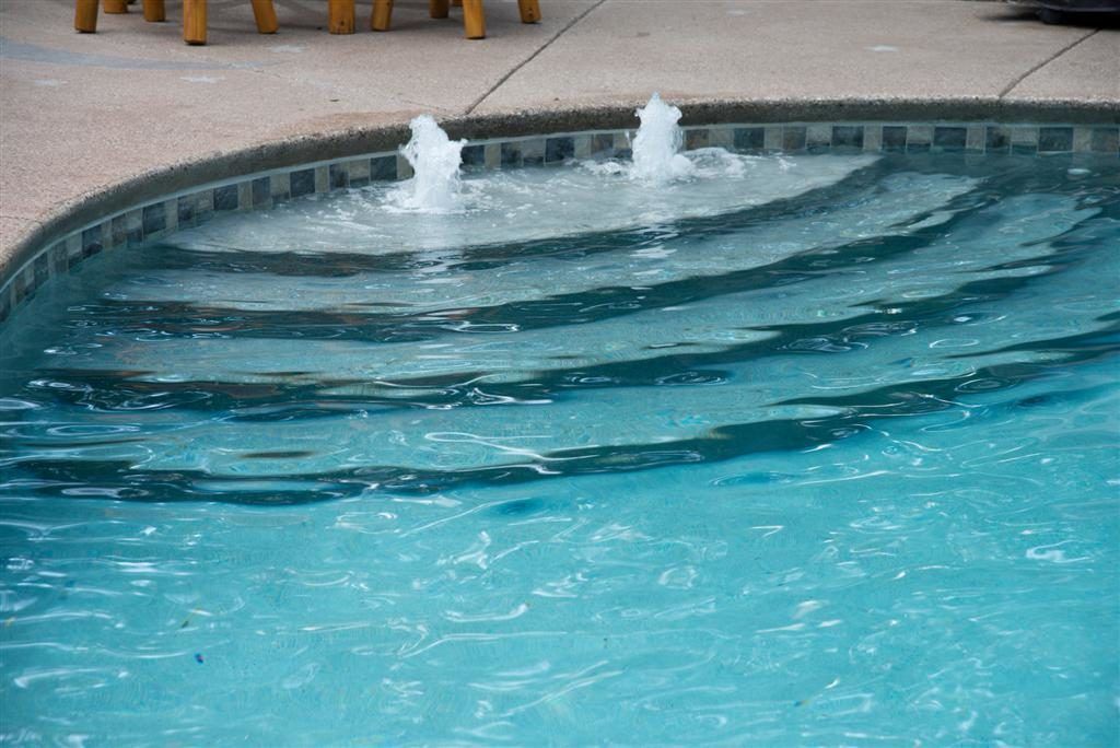 Swimming pool with built-in steps and two water fountains.