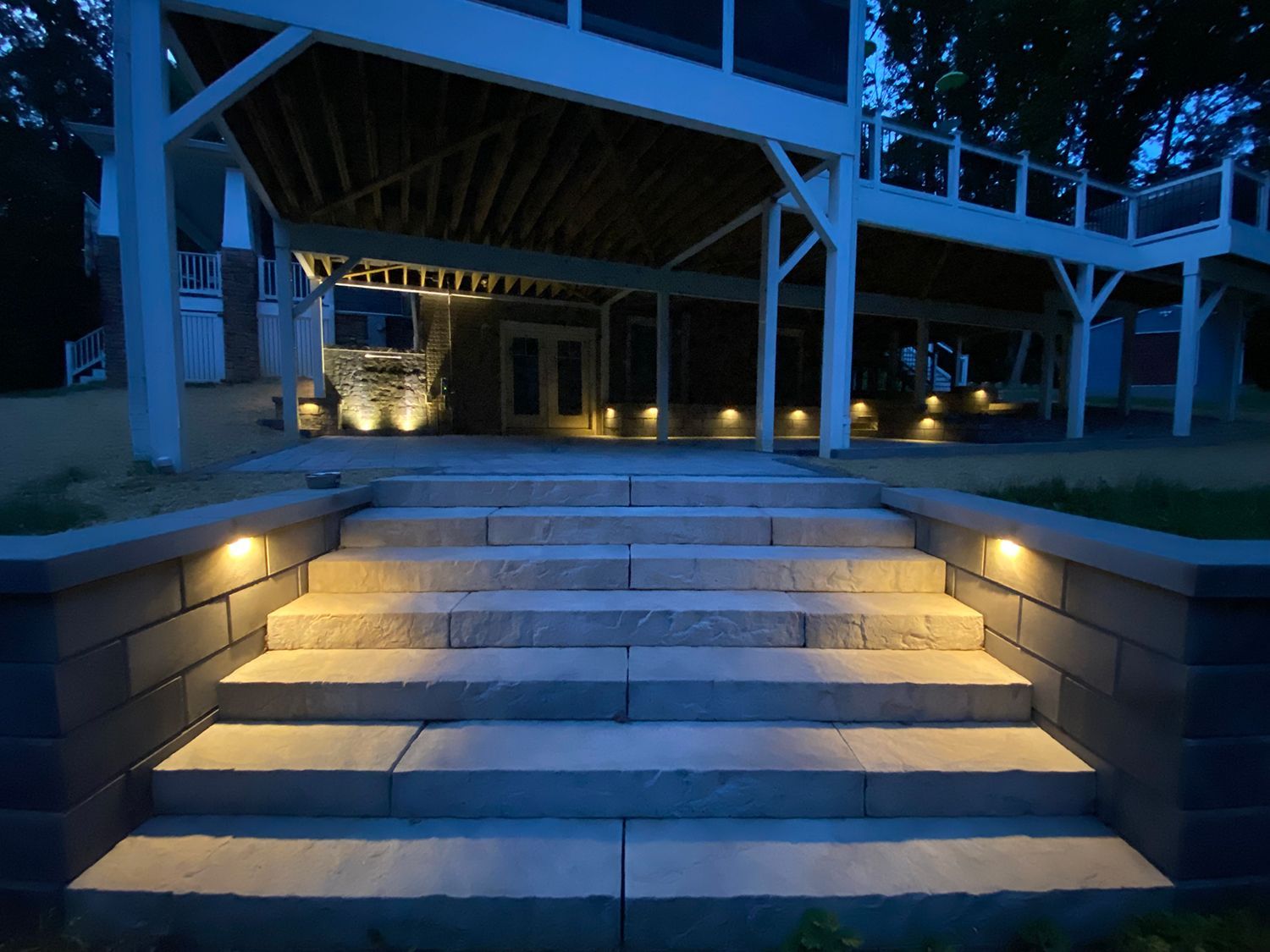 A set of stairs leading up to a house with lights on them.