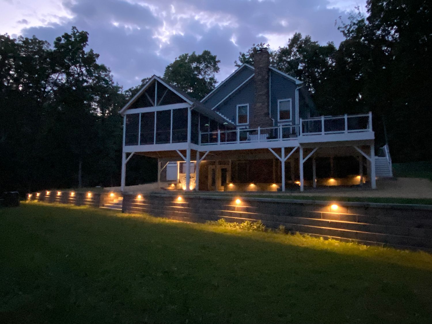A set of stairs leading up to a house with lights on them.