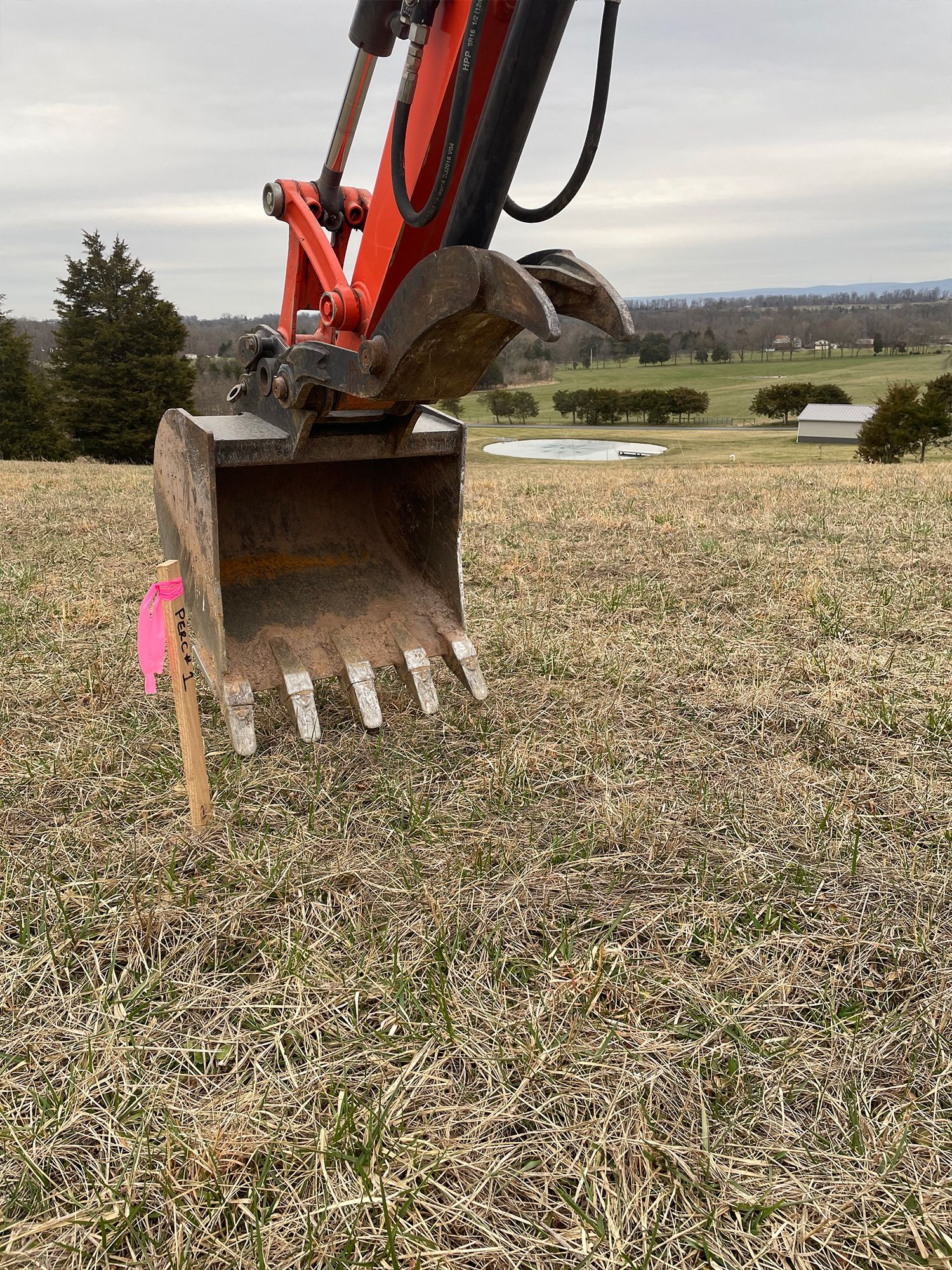 A bulldozer is digging a hole in a field.
