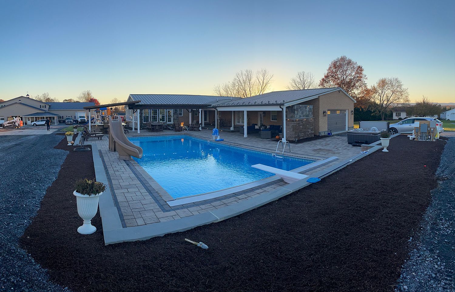A large swimming pool is in the backyard of a house.