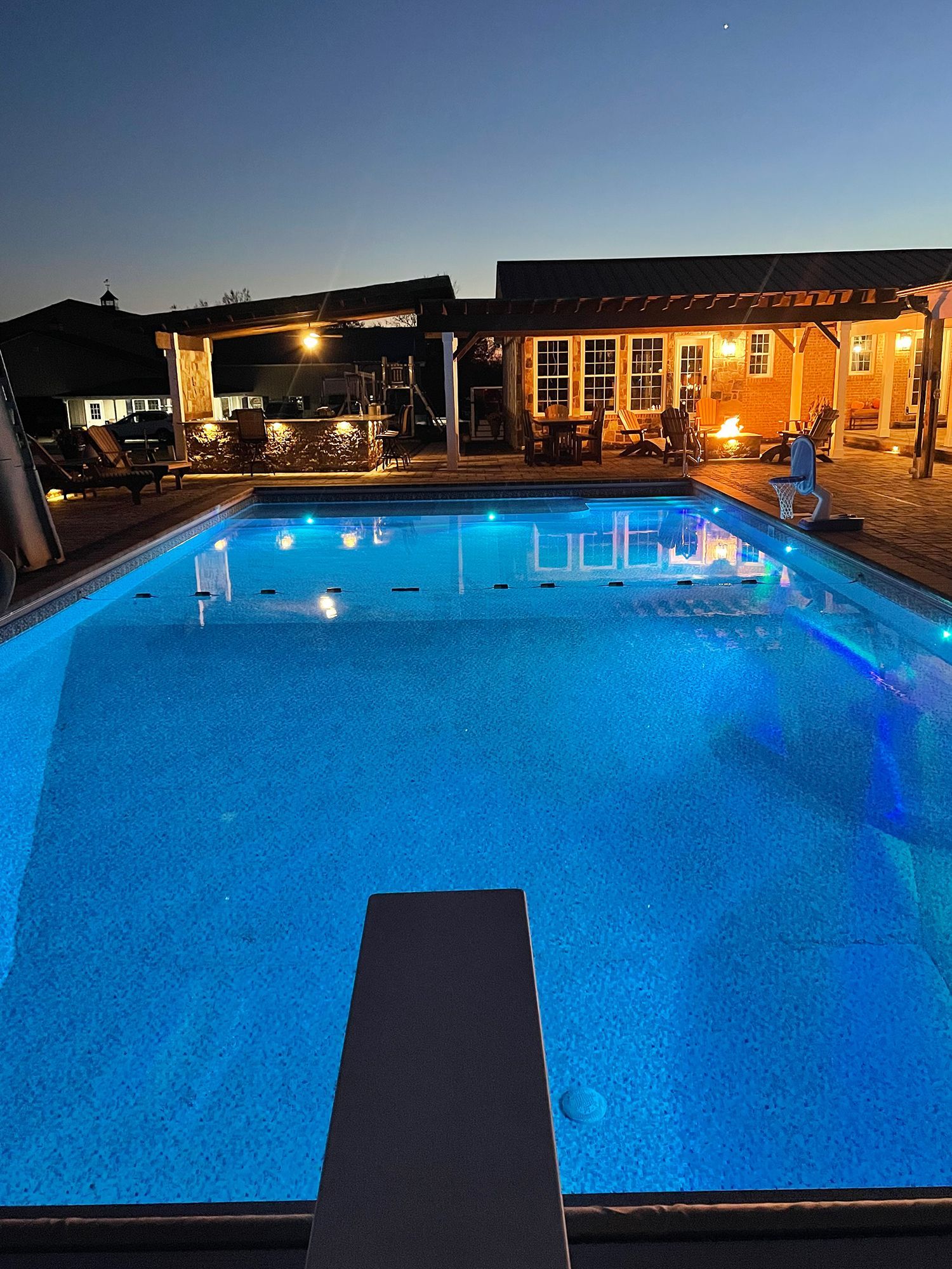 A large swimming pool is lit up at night