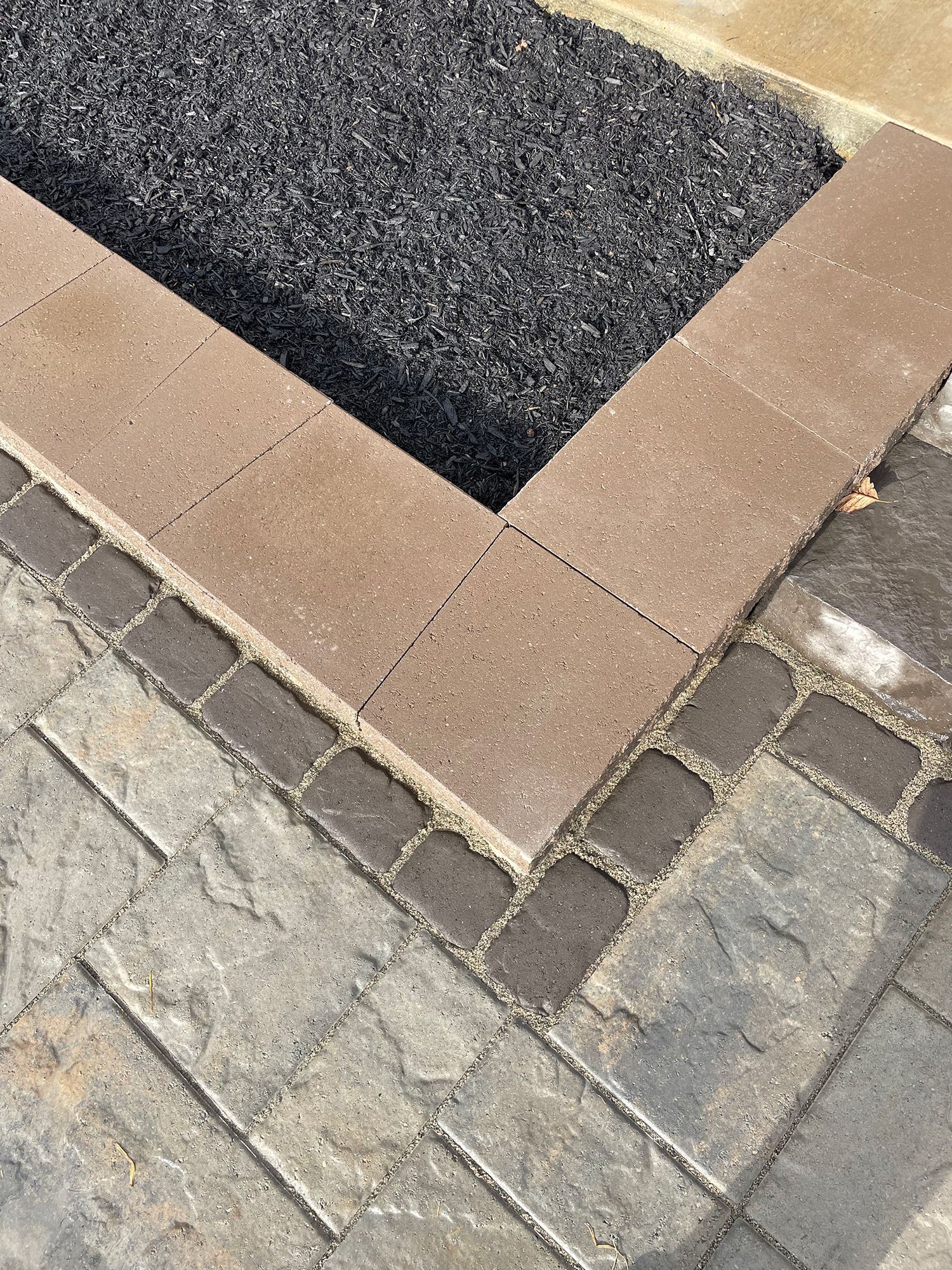 A close up of a brick walkway with a planter in the middle.