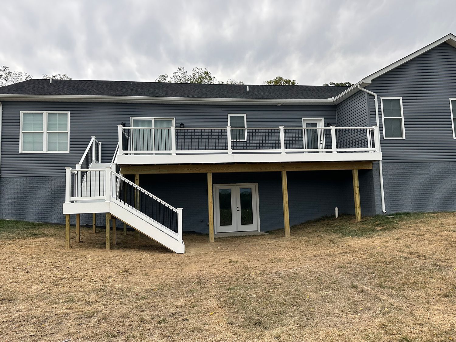 The back of a house with a large deck and stairs.
