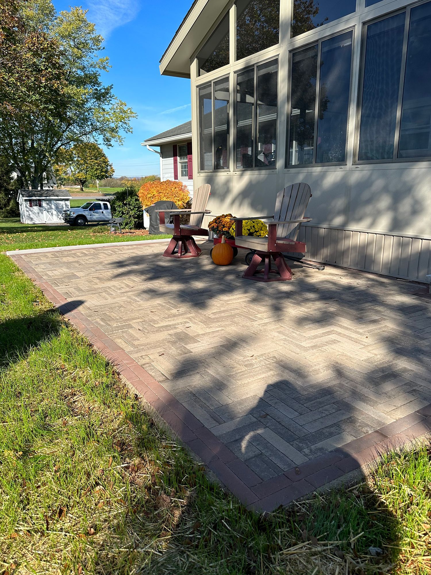 A patio with chairs and a table in front of a house.